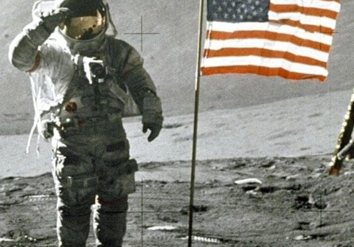 Astronaut saluting US flag on the moon.